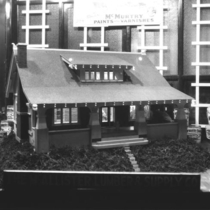 McAllister Company window display with bungalow photograph 1924